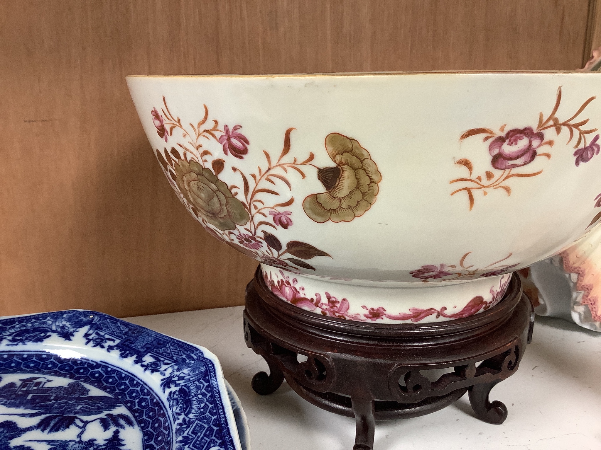 A Chinese export armorial soup plate, a large 18th century Chinese export porcelain footed punch bowl on stand, A Chinese blue and white plates and a pearlware plate